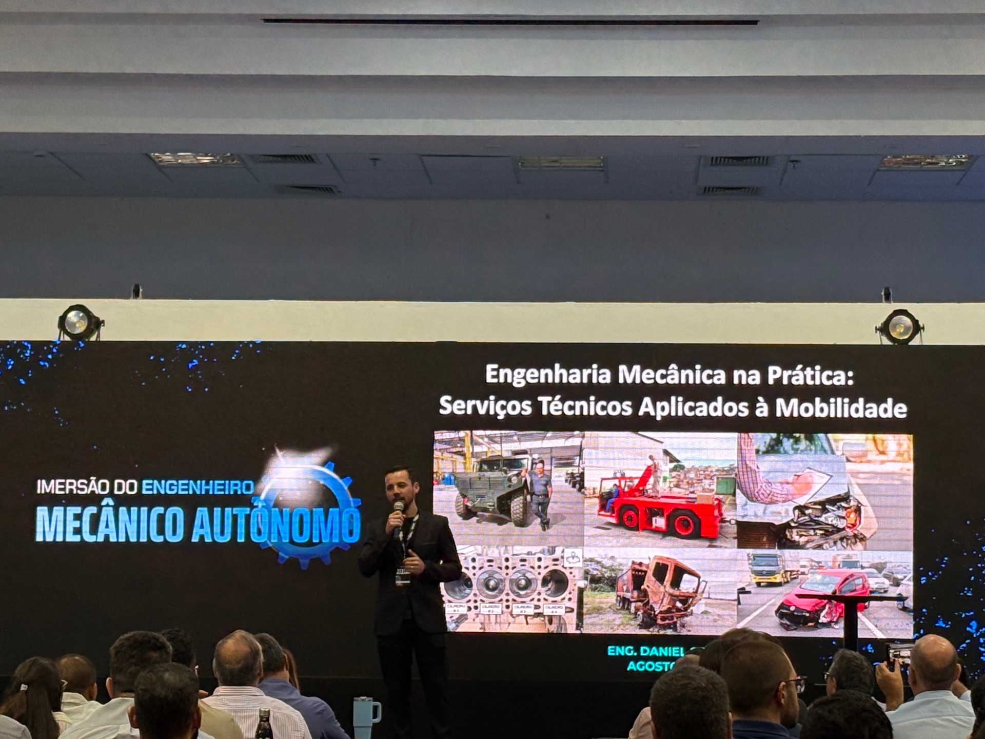 Palestra de engenharia mecânica sobre serviços técnicos aplicados à mobilidade, com Eng. Daniel apresentando em auditório